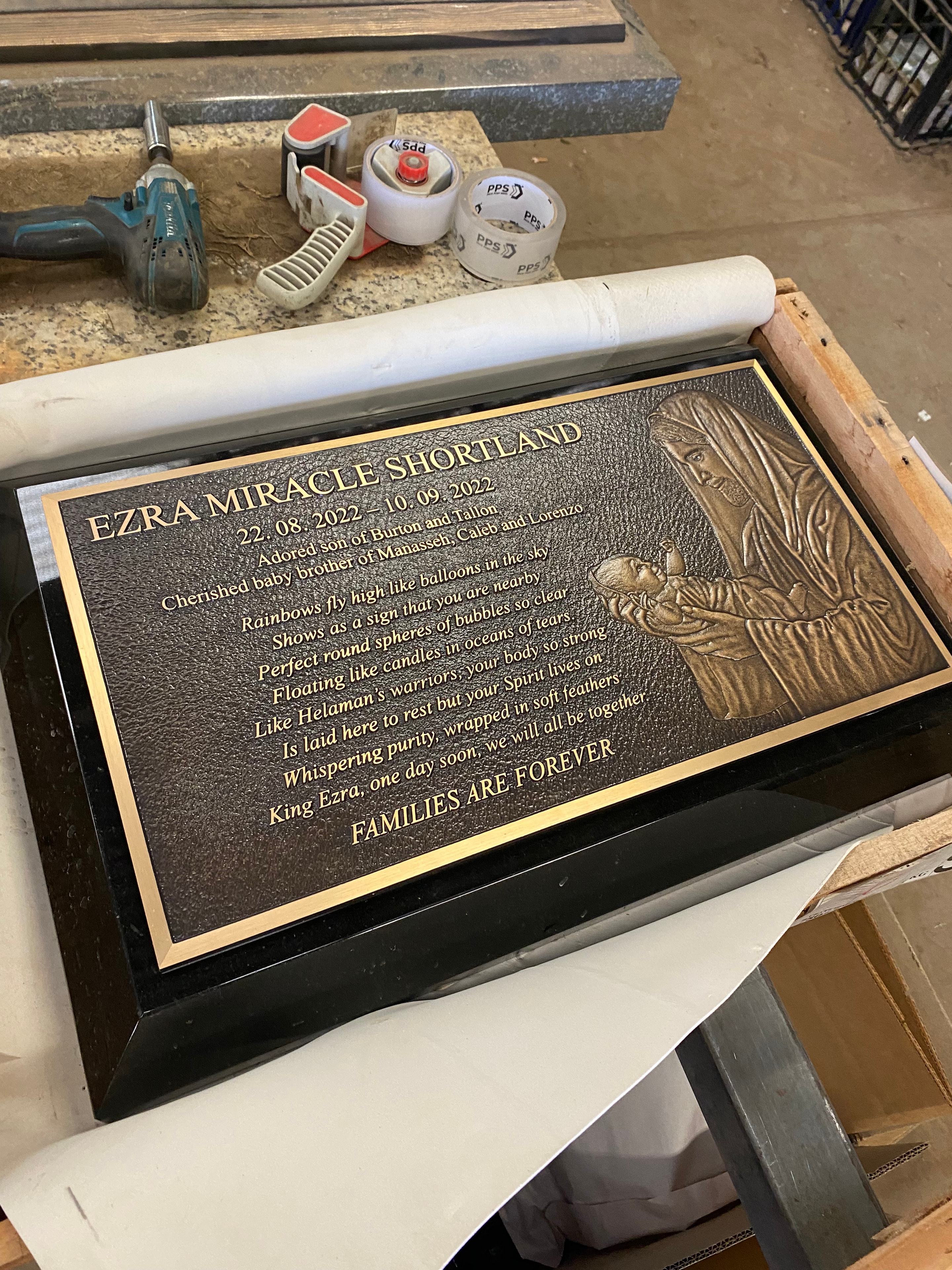 Ezra Miracle Shortland bronze memorial plaque with mother and child relief on black granite