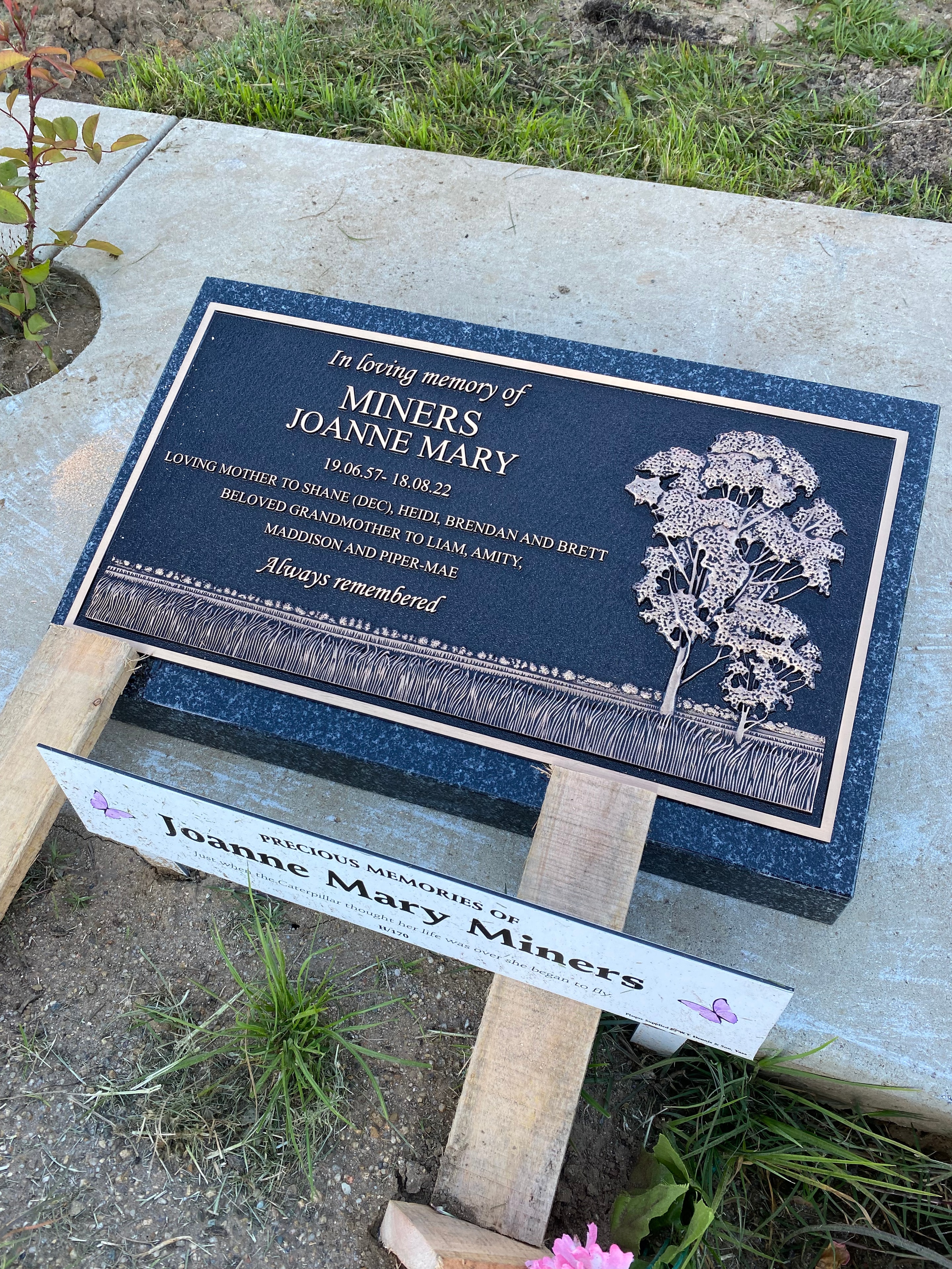 Joanne Mary Miners bronze memorial plaque on dark blue granite