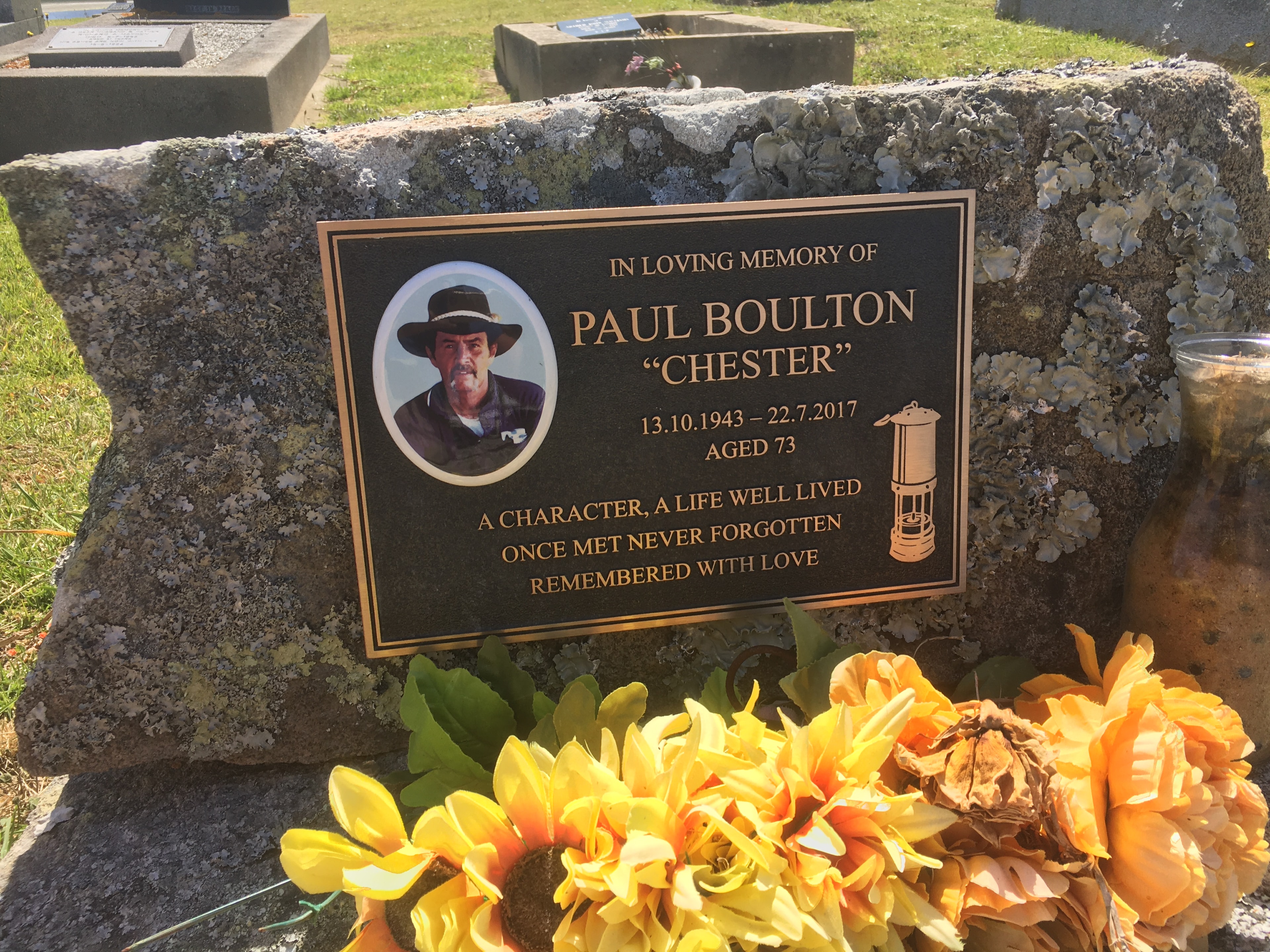 Paul Boulton Chester bronze memorial plaque on a stone memorial with flowers