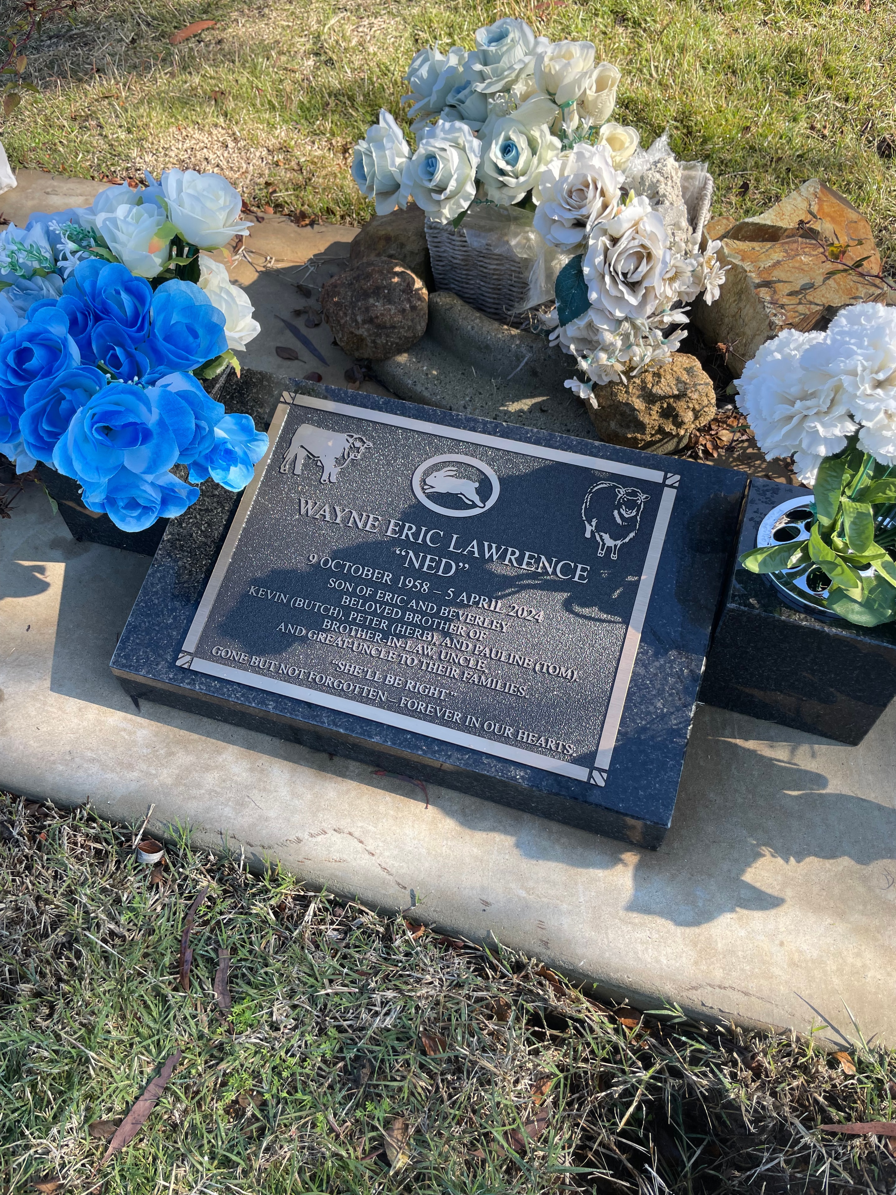 Wayne Eric Lawrence lawn memorial plaque with farm motifs and floral arrangements